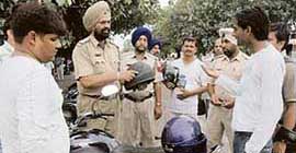 A police official challans traffic offenders during a special drive in Chandigarh on Sunday.