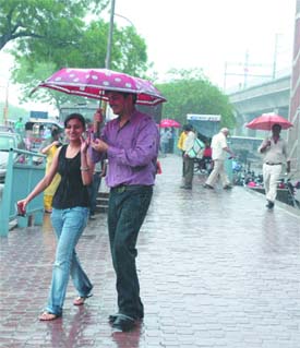 A couple enjoys the rains at Dilshad Garden Metro Station.
