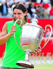 while Nadal bites his trophy after winning the final 7-6, 7-5. Nadals victory made him the first player in 35 years to pull off back-to-back victories in Paris and at the Queens Club and also the first Spanish man to win on turf since Andreas Gimeno in 1972. 