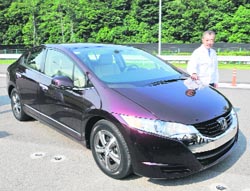 Honda Motor president Takeo Fukui displays the next generation fuel cell vehicle "FCX Clarity" after the line-off ceremony at the company's new model centre at Takanezawa town in Tochigi prefecture, 100 km north of Tokyo, on Monday. American Honda Motor will deliver the vehicles to the first customer in July. 