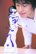 Sega Toy's female humanoid robot, Eternal Maiden Actualisation (EMA), kisses a man at its demonstration in Tokyo on Monday. The robot, which has a womanish appearance, is able to walk, dance and kiss humans. It will be sold in the domestic market from September 26 with a price tag of $166. 