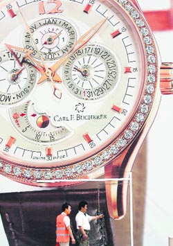 Two Chinese men stand beside a giant billboard for a luxury watch in Beijing on Monday. China's economic growth will slow to 10.4 per cent in 2008, likely marking the start of a slowdown which could take several years, as the country's GDP expanded by 10.6 per cent in the first three months of 2008 from a year earlier, easing from 11.9 per cent for the full year of 2007. 