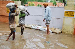 CHARITY BEGINS AT HOME: Sandbags being placed at the PWD House, Bathinda, to block the entrance of rainwater on Monday. But does authorities concerned care about hundreds of houses that have also been inundated after the heavy showers? 