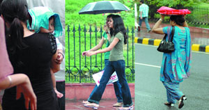 People protect themselves during the monsoon rain in New Delhi on Monday.