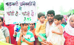 Saritas husband Subhash carries his two daughters during a protest in Rohtak on Monday.