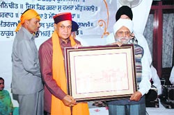 An office-bearer of the Singh Sabha presents a portrait of Harmandar Sahib to Chief Minister P.K. Dhumal in Shimla