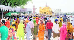 Devotees throng the Golden Temple to pay obeisance on the martyrdom day of Guru Arjan Dev in Amritsar on Monday.