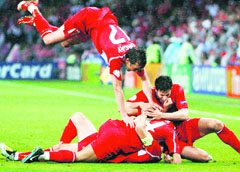 Turkish player Tuncay Sanli jumps onto his teammates to celebrate after Nihat Kahveci scored his teams third goal during the final group A match on Sunday at the Stade de Geneve, in Geneva.