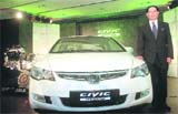 President and CEO of Honda Siel Cars India, Masahiro Takedagawa poses with Indias first hydrid car, Hondas Civic Hydrid, at its launch in New Delhi 