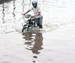 A motorcyclist wades through a waterlogged NH-8 at Hero Honda Chowk in Gurgaon on Wednesday. 