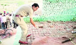 A police officer inspects the scene where Rajus body was found in Ludhiana on Wednesday. 