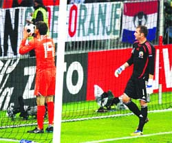 Netherlands' Klaas-Jan Huntelaar (L) kisses the match ball in the goal net as he celebrates his goal watched by Romania's goalkeeper Bogdan Lobont during the Group C Euro 2008 soccer match at the Stade de Suisse stadium in Bern, on Tuesday.