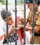 A security personnel pushes a Greenpeace activist outside the Health Ministry in New Delhi on Thursday.