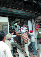 Police and firebrigade officials rescue people trapped under the debris after the roof collapse of an old building in Amritsar on Thursday.