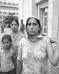 Gurmail Kaur shows her torn clothes. Also in the picture are Harpreet Kaur and Kawalpreet Kaur who were thrashed by cops