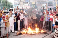 Members of the Sikh community burn the effigy of Dera Sacha Sauda chief Gurmeet Ram Rahim in Bathinda 