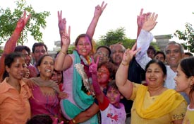 Independent candidate Rachna Oberois supporter lift her up after she won from ward number 49.