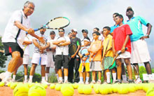 Former Davis Cup coach and player Akhtar Ali gives tips to budding tennis players at the Chandigarh Club Tennis Academy on Sunday.