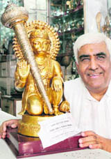 AICC member Brijmohan Bhama poses with the 2-ft high gold-plated idol of Lord Hanuman to be presented to US Democratic presidential candidate Barack Obama as a gift, in New Delhi on Sunday.