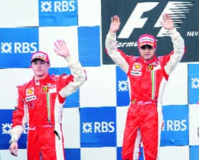 Ferraris Finnish driver Kimi Raikkonen (L) and Ferrari Brazilians driver Felipe Massa celebrate on the podium of the Magny-Cours racetrack