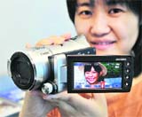 A Sony employee displays the new high-definition digital camcorder Handycam HDR-CX12, equipped with a 5.6 mega-pixel CMOS sensor and a 4.9-58.8/F1.8-3.1 zoom lens, equivalent to 40-480 mm in 35 mm camera, in Tokyo
