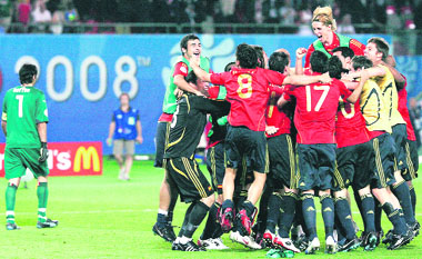Italian goalkeeper Gianluigi Buffon (L) walks past Spanish players as they celebrate at the end of the quarterfinal match at Ernst Happel stadium in Vienna on Sunday.
