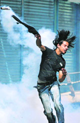 A Kashmiri protester throws back a tear gas shell towards the police during a protest in Srinagar on Tuesday.