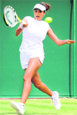 Sania Mirza returns the ball to her Colombian opponent Catalina Castano during the first round of the Wimbledon championships in London