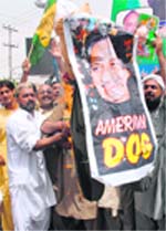 Supporters of PML(N) burn pictures of President Pervez Musharraf during a protest against the disqualification of former prime minister Nawaz Sharif in Multan