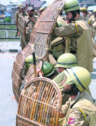 Policemen take guard against the violent crowd in Srinagar on Thursday.