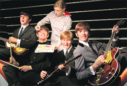 An assistant gives final touches to wax figures of The Beatles during a promotion for their musical "All You Need is Love!" in Berlin