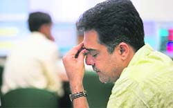 A broker reacts while trading at a stock brokerage firm in Mumbai on Friday. Shares tumbled 4.3 per cent, their biggest drop in three months, as record world oil prices kept the focus firmly on inflation and raised the spectre of more monetary tightening in coming months.