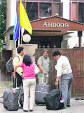 Tourists wait outside a closed hotel in Srinagar on Friday.