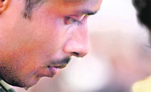 A soldier sweats as he stands guard outside an Army camp in Jammu on Friday. 