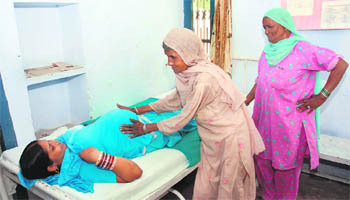 Shanti Devi, a trained dai, examines a woman at a delivery hut in Byana village, 20 km from Karnal, in Haryana