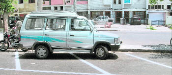 It is common to see a vehicle in an almost empty lot, parked horizontally, and taking up extra parking space