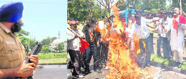 A security guard keeps watch as workers of the Bajrang Dal burn the effigy of former PDP chief Mufti Mohammad Sayeed near Jama Masjid, Sector 20, Chandigarh, on Saturday.