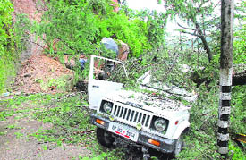 A vehicle that was badly damaged after a tree fell on it on the national highway following heavy rain in Shimla on Saturday.