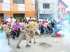 Policemen fire tear gas shells at agitating protesters who staged demonstrations against the ongoing violence in the valley in Srinagar on Saturday.