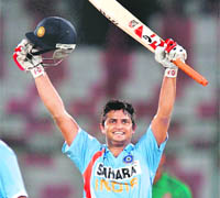 Suresh Raina raises his bat after his century during the Super League Asia Cup match between India and Bangladesh in Karachi on Saturday. 