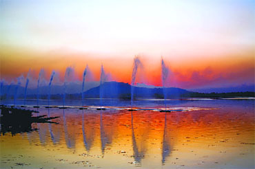 The hues of the setting sun lend a surreal charm to the placid waters of Dal Lake, Srinagar