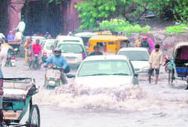 Motorists have a tough time moving through an inundated road following a downpour in Ludhiana