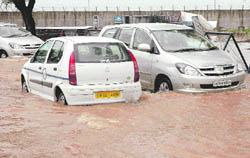 Motorists have a tough time to make their way through the flooded parking at the Chandigarh airport