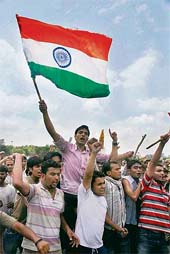 Members of various Hindu organisations hold aloft a Tricolour and raise slogans against the Jammu and Kashmir Government for its decision of revoking land transfer to the Shri Amarnath Shrine Board in Jammu on Monday.