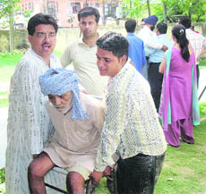 An elderly man being helped to reach a polling booth in Pathankot on Monday. 