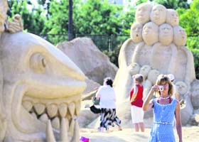 A tourist takes a picture of a sand sculpture before the official opening of the Ist international sand sculptures festival in the Bulgarian city of Bourgas, around 390 km from capital Sofia