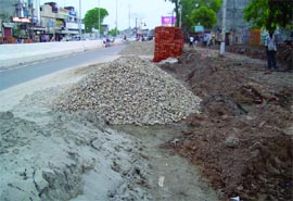 Sand, stone chips, bricks lying on the Bathinda-Goniana road leaving little space for vehicles to move. 
