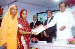 Finance minister P Chidambaram offers financial assistance to women self-help groups on behalf of the SBI, as the bank chairman O.P. Bhatt (2nd from right) and deputy managing director Anup Banerjee look on, at the online opening of 101 SBI branches across the country simultaneously, in New Delhi on Tuesday. 