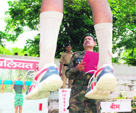 A candidate undergoes a physical test as an official looks on at an Army recruitment camp in Karnal on Tuesday. 