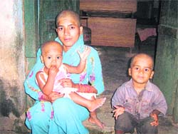 Sonia Kumari and her two kids with their heads tonsured.